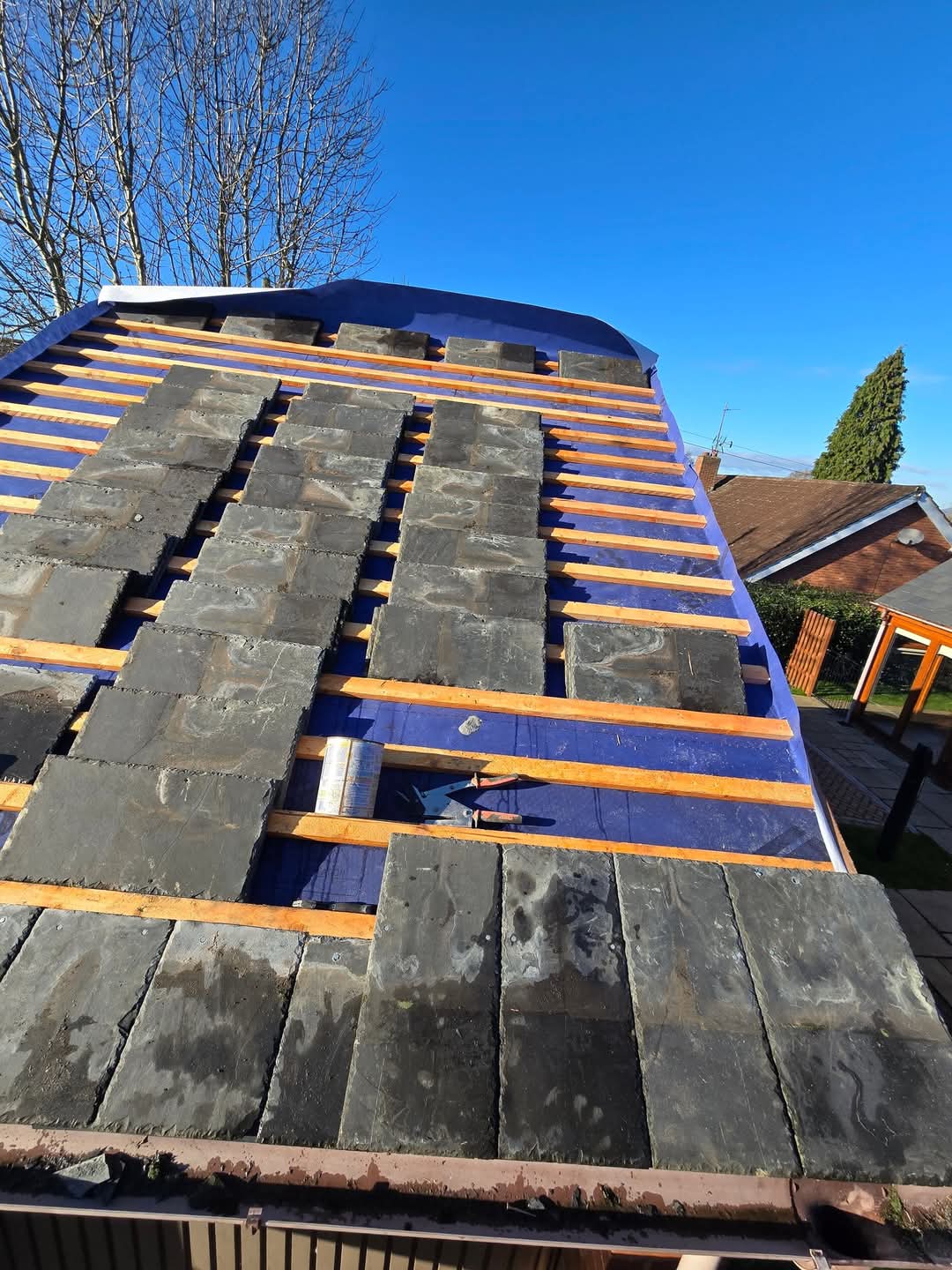 Slates being re-laid on new battens with breathable membrane