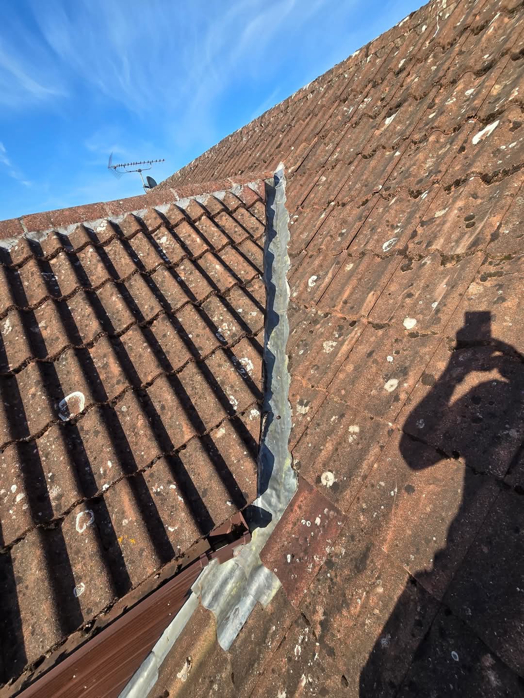 Failing lead valley with cracked cement bedding — leak at base