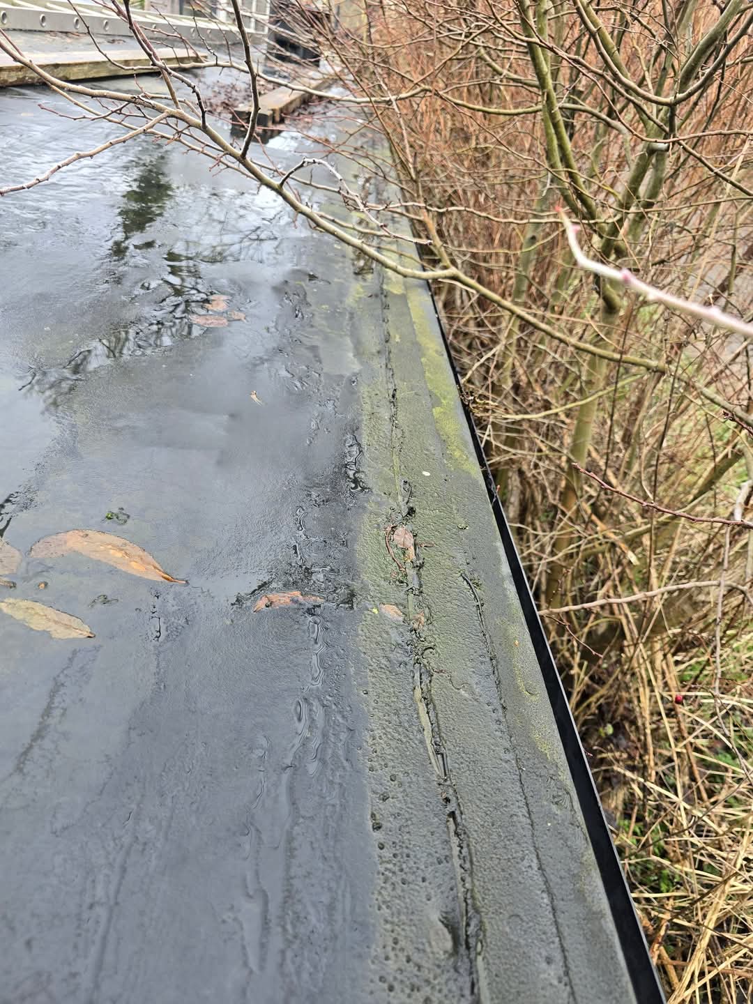 Failing EPDM nailed down with DPC tape — leaking edge